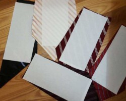 Dei rettangoli di carta biadesiva incollati sul retro di pezzi di cravatta.